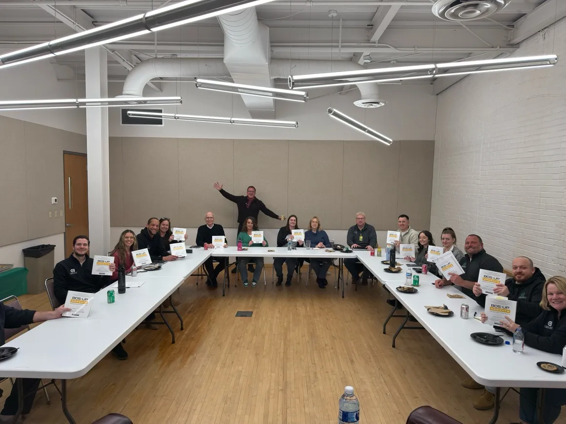 Team holding up BOS-UP Moments books after a session